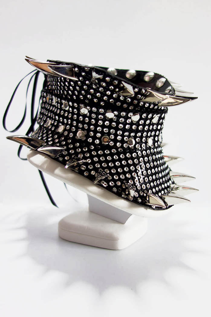 Black studded collar on a white stand against a white background