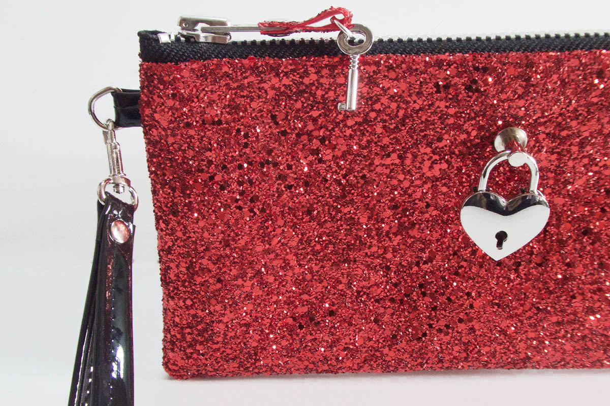 Red glittery pouch with a heart-shaped lock charm on a white background