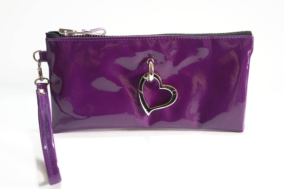 Purple clutch bag with a heart-shaped charm on a white background