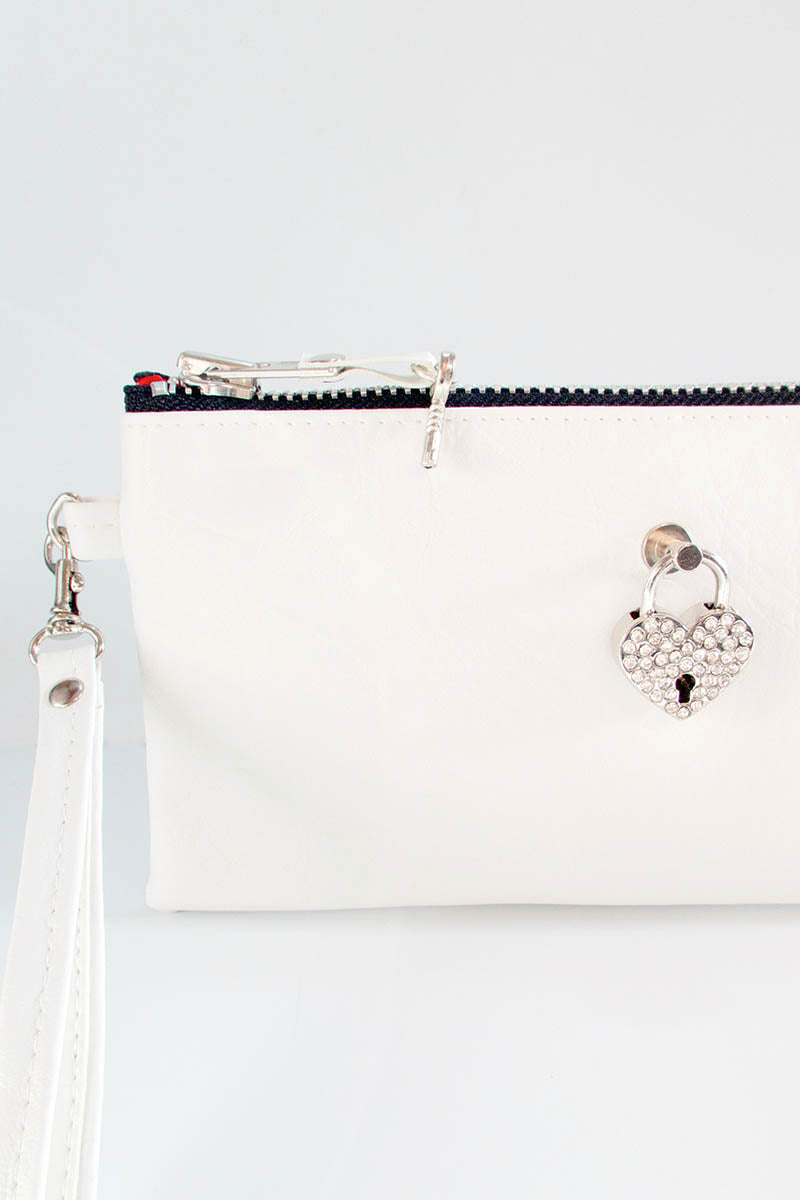 White handbag with decorative clasp on a light gray background