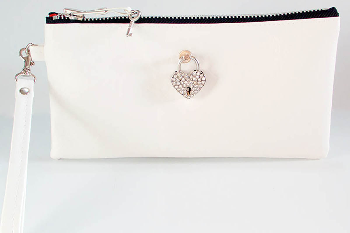 White clutch bag with a heart-shaped clasp on a light gray background