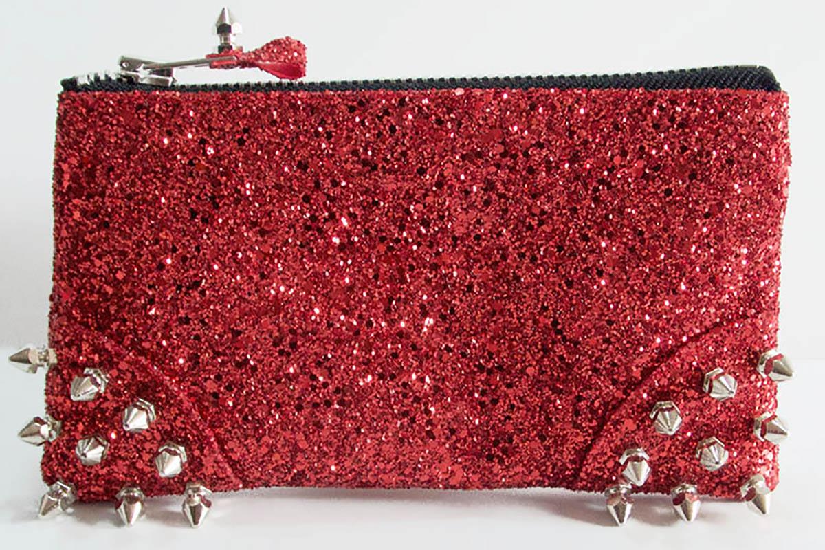 Red glittery pouch with silver spikes on a white background