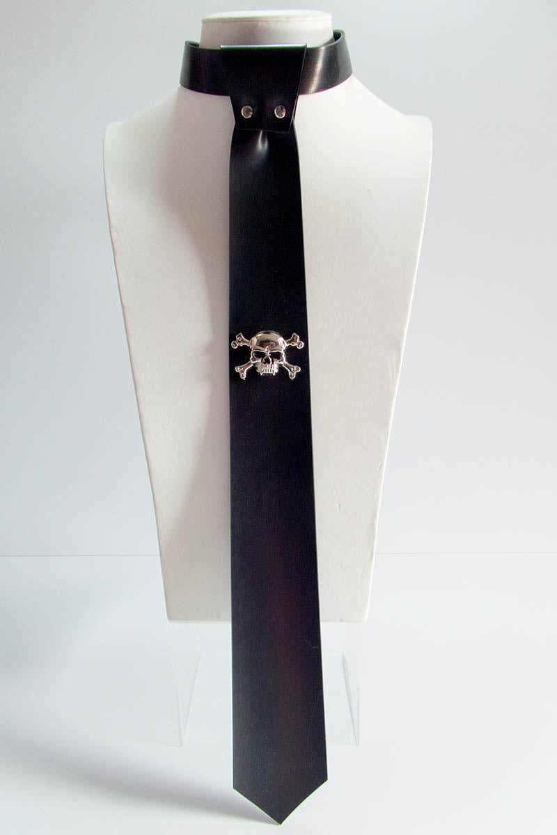 A black skinny tie with a skull and crossbones stud, displayed on a mannequin.