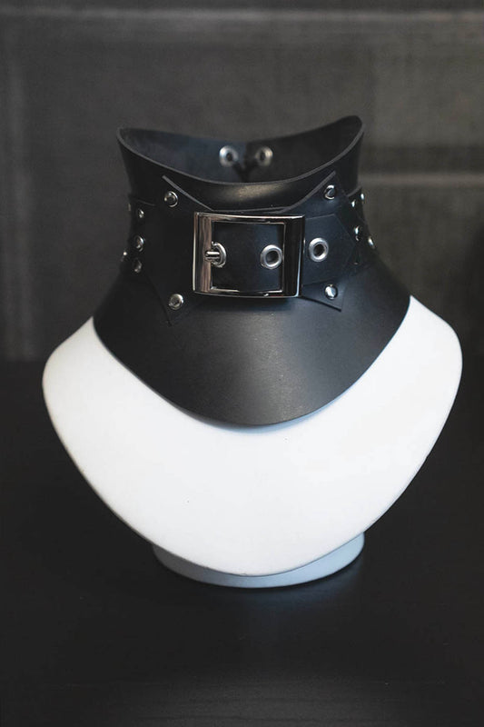 Black rubber choker with buckle on a white mannequin bust against a dark background