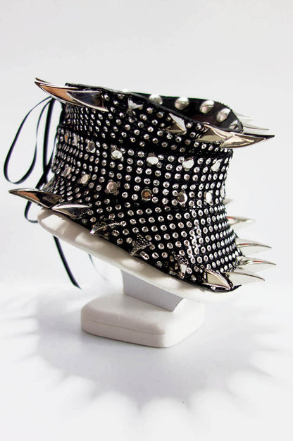 Black studded collar on a white stand against a white background