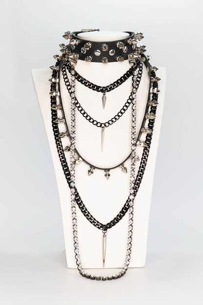 Layered necklace on a white stand with a plain background