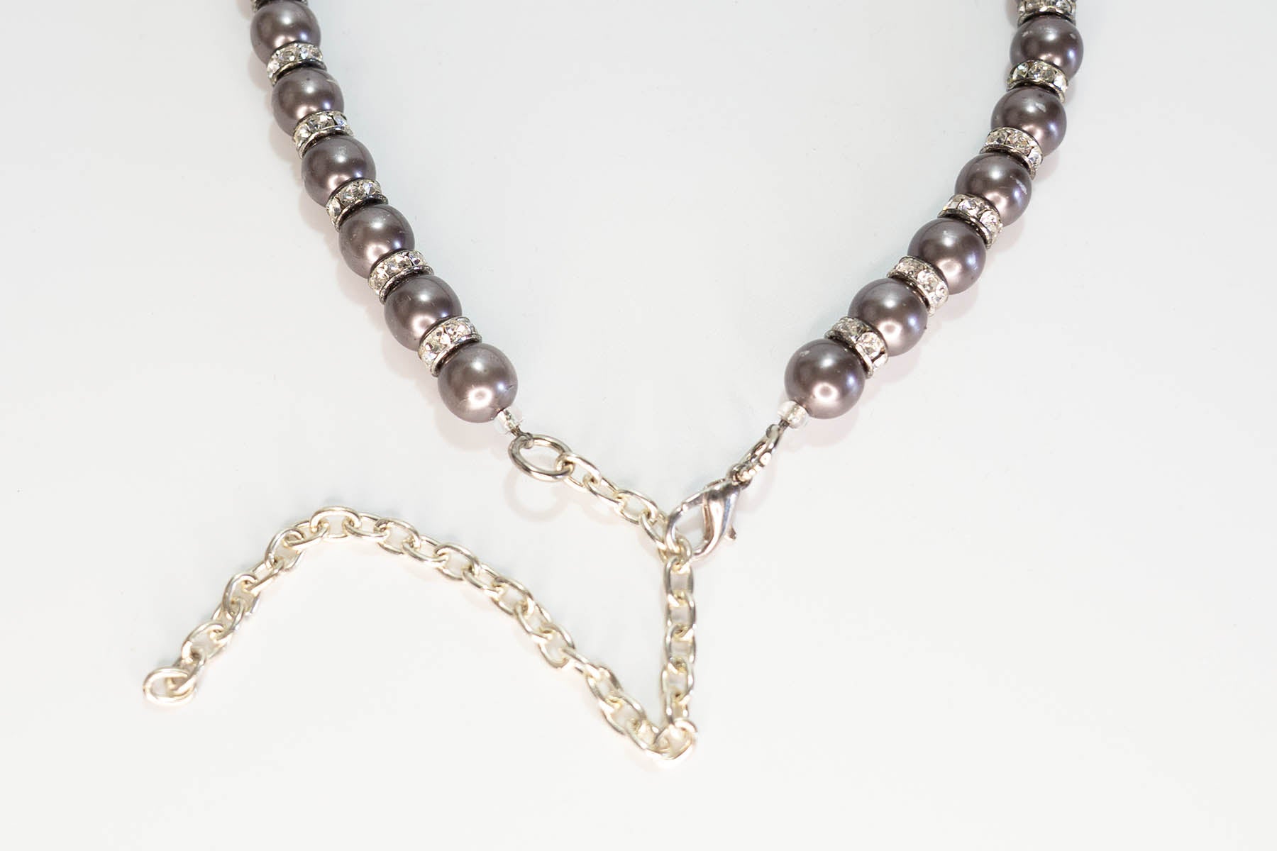 Necklace with grey beads and silver chain on a white background