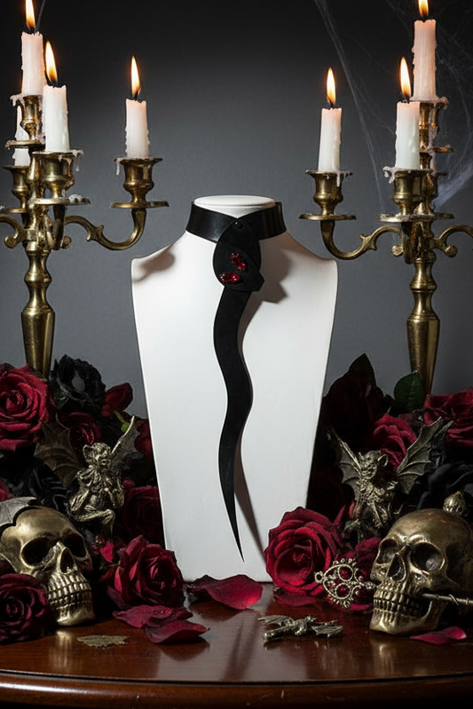 White dress form with black belt surrounded by candles, roses, and skulls on a dark background