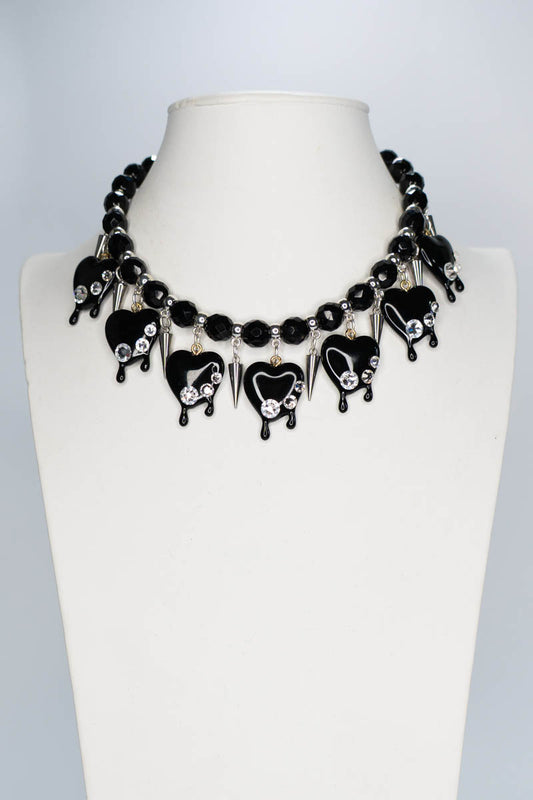 Black and silver necklace on a mannequin bust against a white background