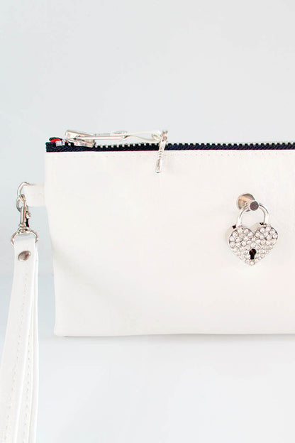 White handbag with decorative clasp on a light gray background