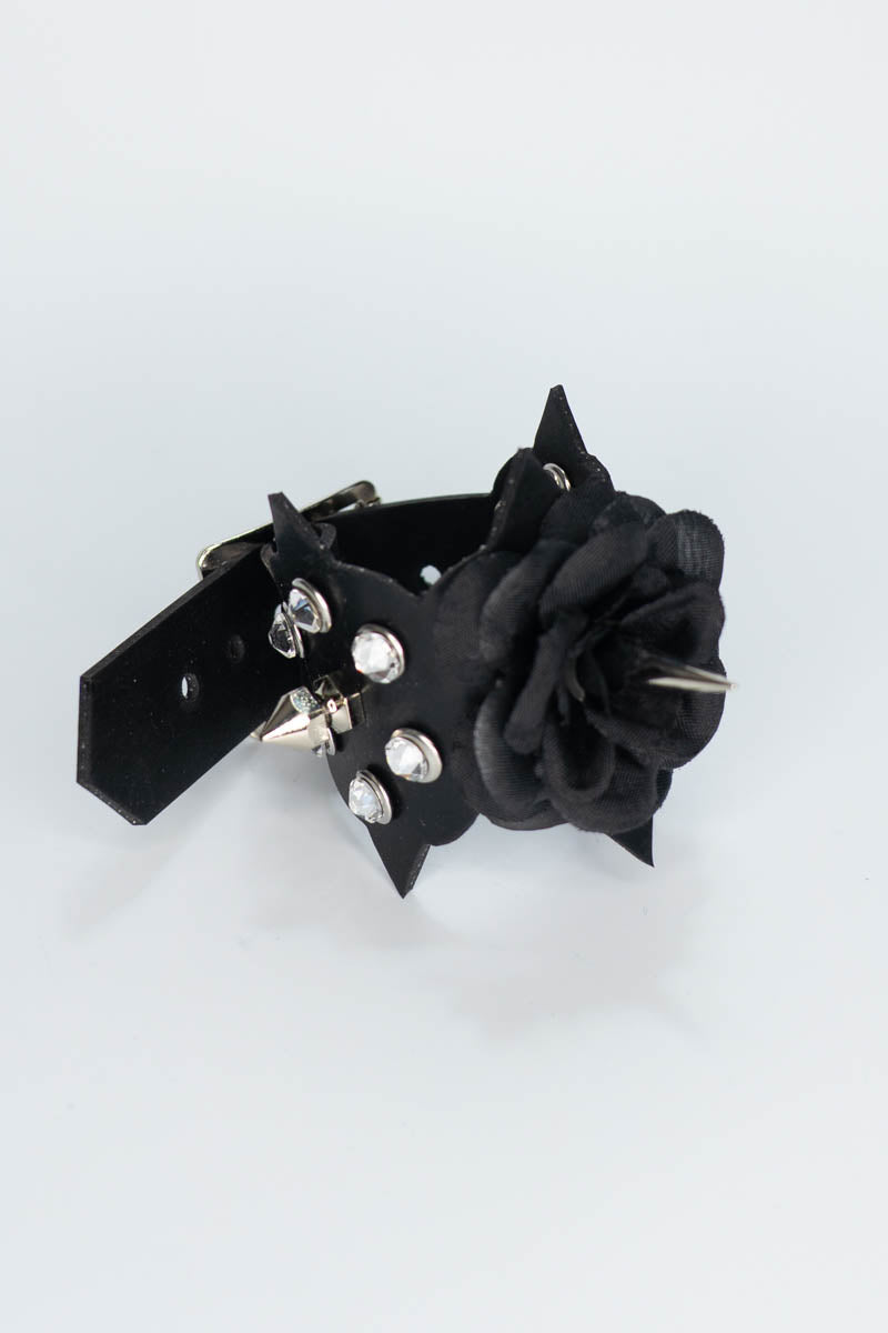 Black rubber bracelet with floral design and silver studs on a white background