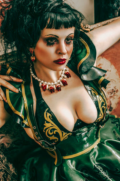 beautiful dark haired girl with striking green costume on a chaise longue
