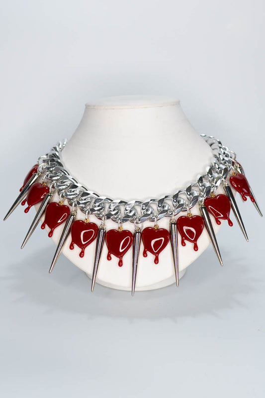 Necklace with heart-shaped pendants and spike-like elements on a white background