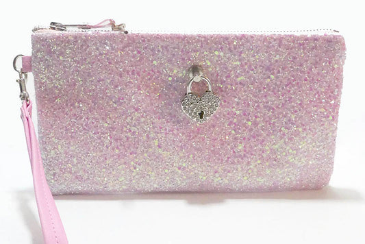Pink glittery clutch with a heart-shaped lock charm on a white background