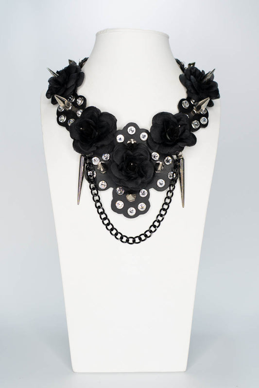 Black floral necklace with chain on a white mannequin bust