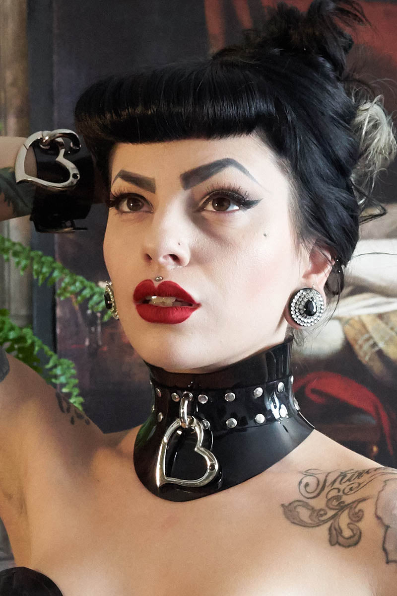 dark haired fetish model wears a corset collar