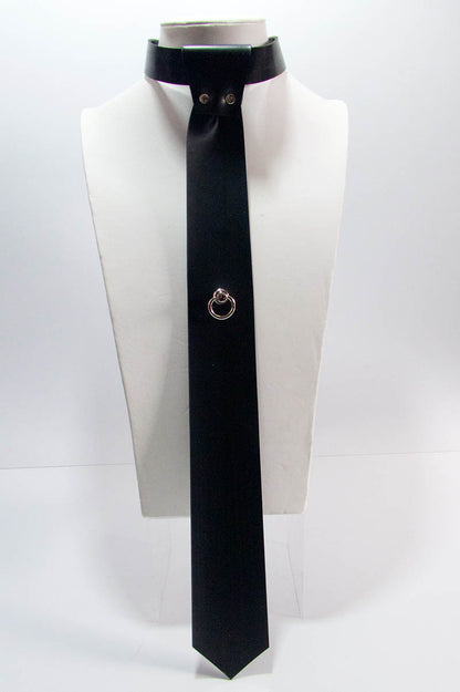 A black skinny tie with a swivel ring mounted on a mannequin's neck.