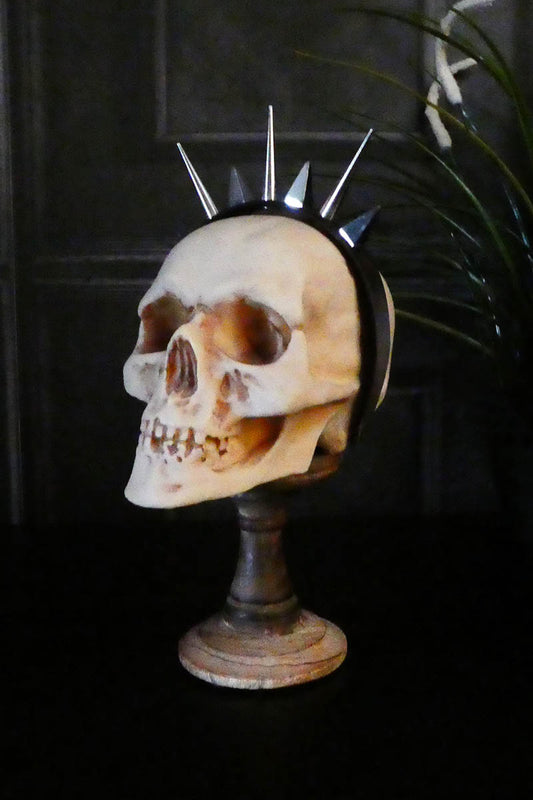 A decorative hairband with three pointed toppers and four pyramid-shaped spikes, displayed on a mannequin head.